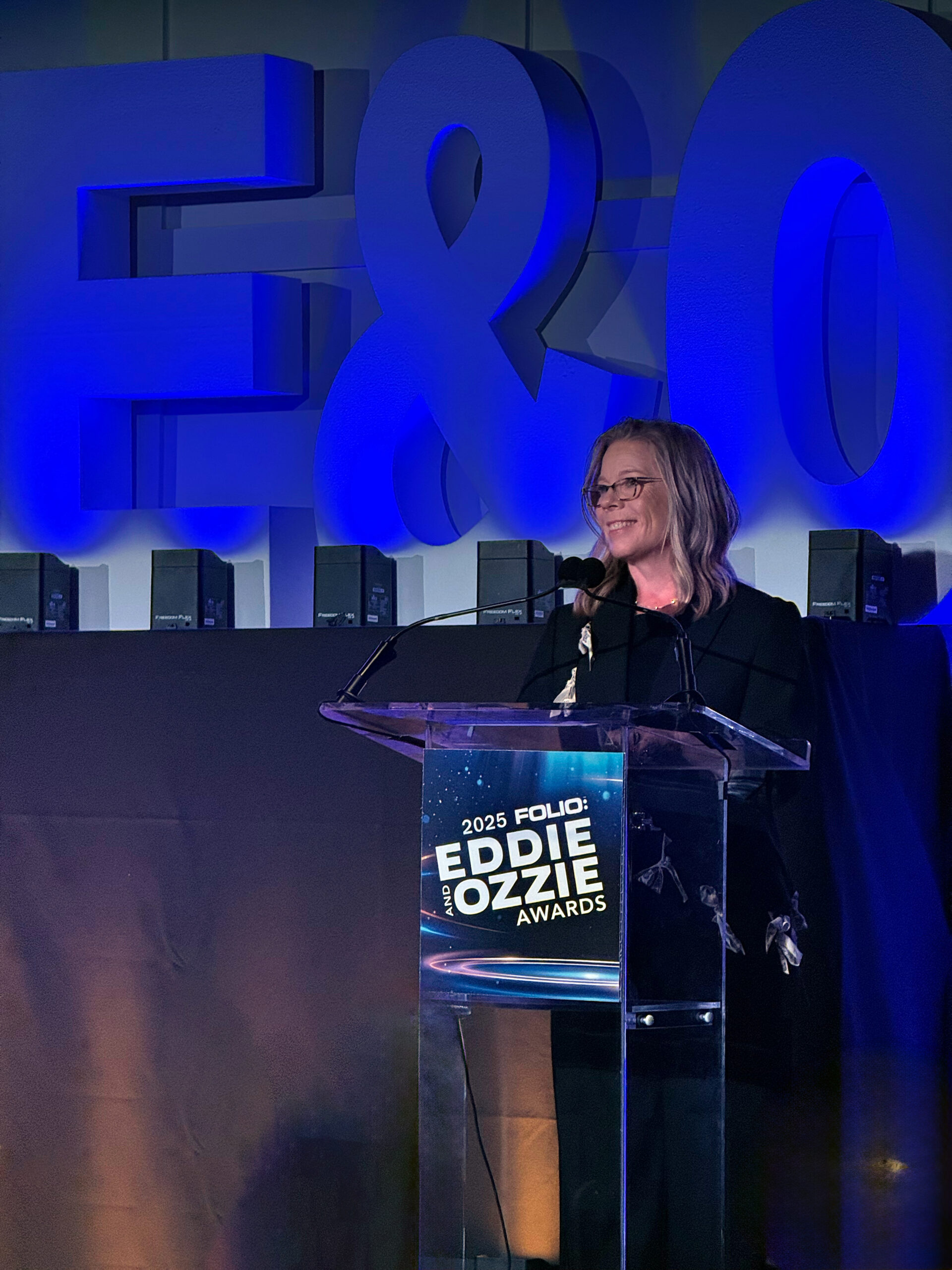 Nancy Glick of Glick and Fray speaking at podium during the Ozzie/Eddie Awards 2025