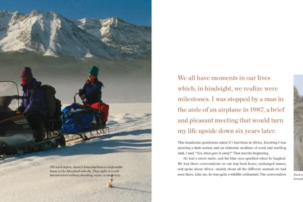 A two-page spread titled ARRIVAL features a snowy mountain landscape with people on snowmobiles and a person surrounded by wolves, alongside products describing the experience. | Living with Wolves